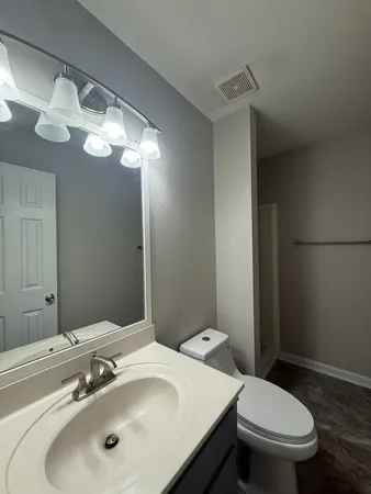 a bathroom with a sink a toilet and a mirror