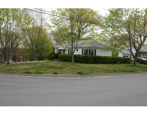 a view of a house with a big yard and large trees