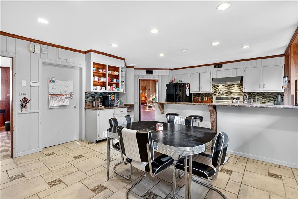 32 McDonough Street Hampton, GA 30228 - Photo 40 of 59 a kitchen with stainless steel appliances kitchen island granite countertop a refrigerator and a stove top oven