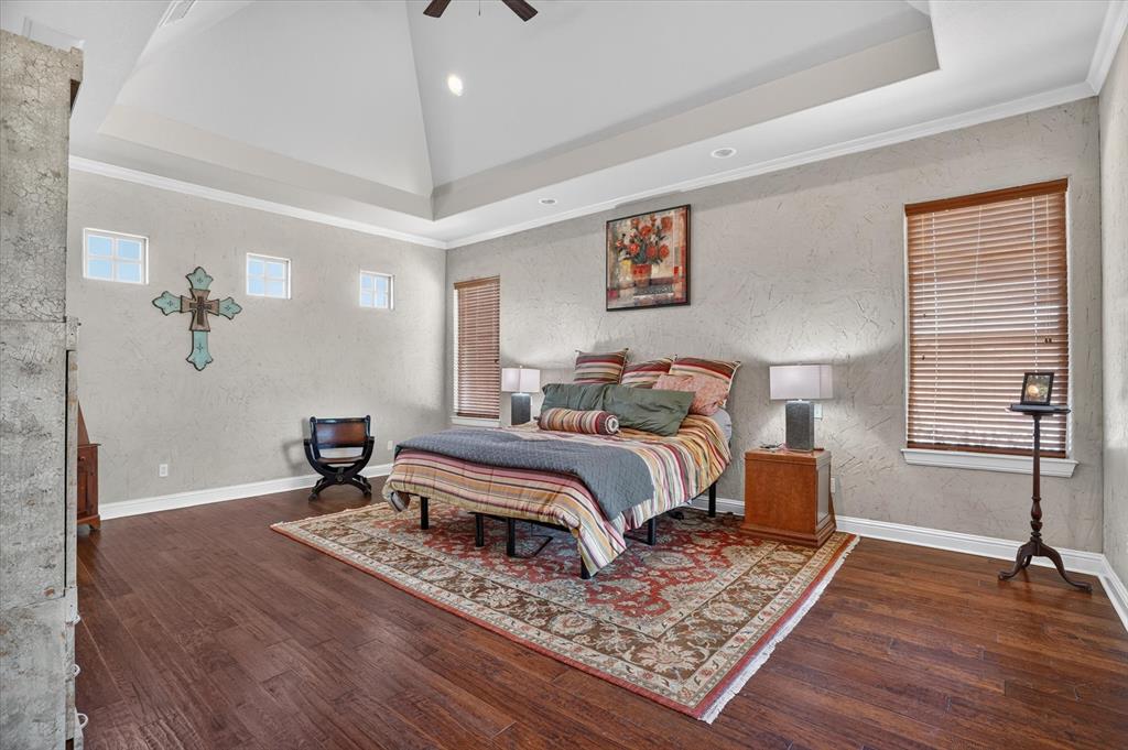 100 Canyon Ridge Trail Aledo, TX 76008 - Photo 22 of 38 Spacious primary bedroom featuring a coffered ceiling with recessed lighting, hardwood flooring throughout, and large windows with wood-finish blinds