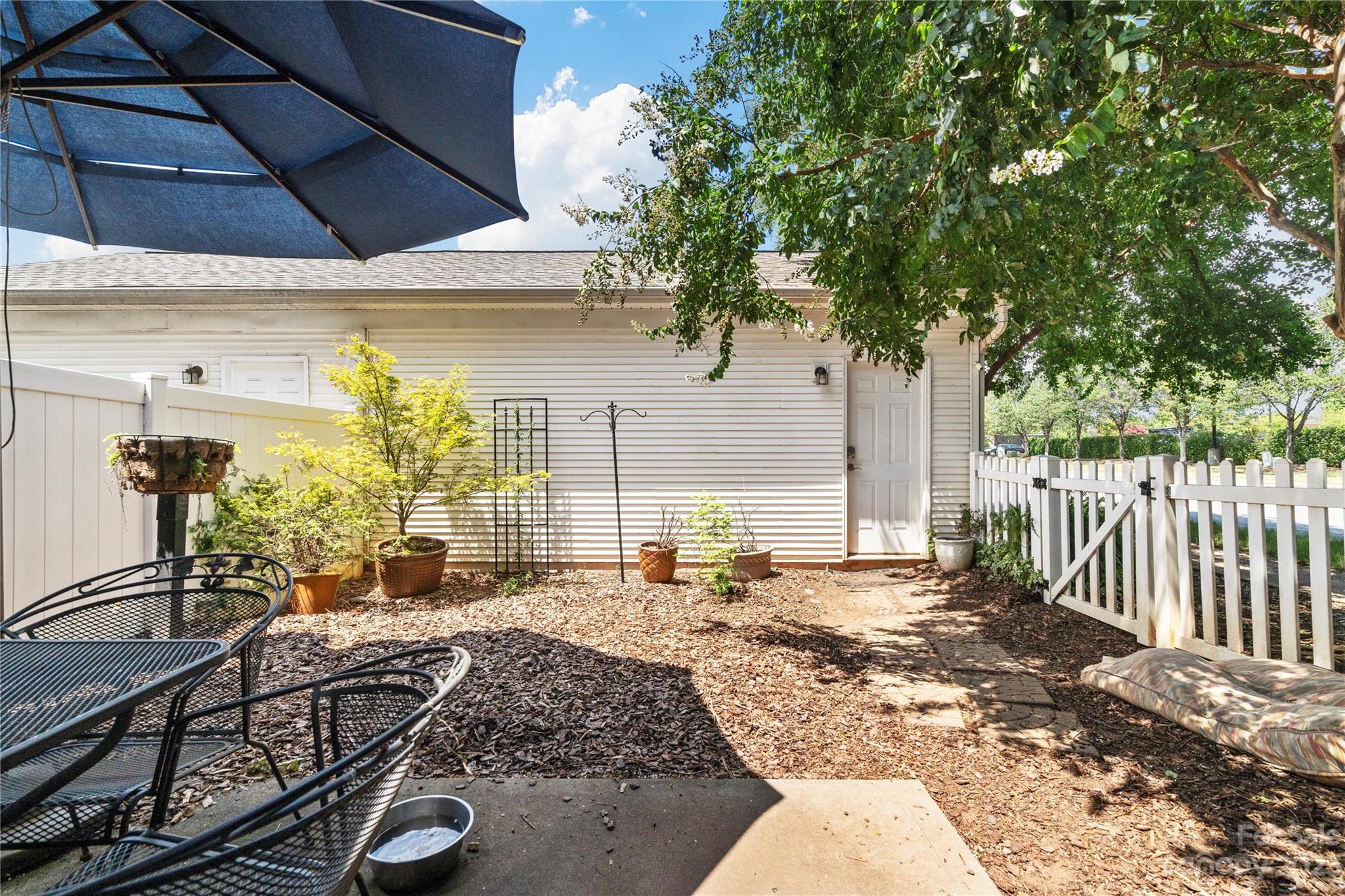 118 Singleton Road Mooresville, NC 28117 - Photo 3 of 28 a view of a patio with table and chairs potted plants with wooden fence
