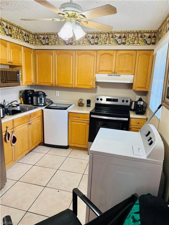 3325 Airport Road North, Unit R6 Naples, FL 34105 - Photo 6 of 11 Kitchen with washer / clothes dryer, a ceiling fan, stainless steel appliances, light countertops, and light tile patterned floors