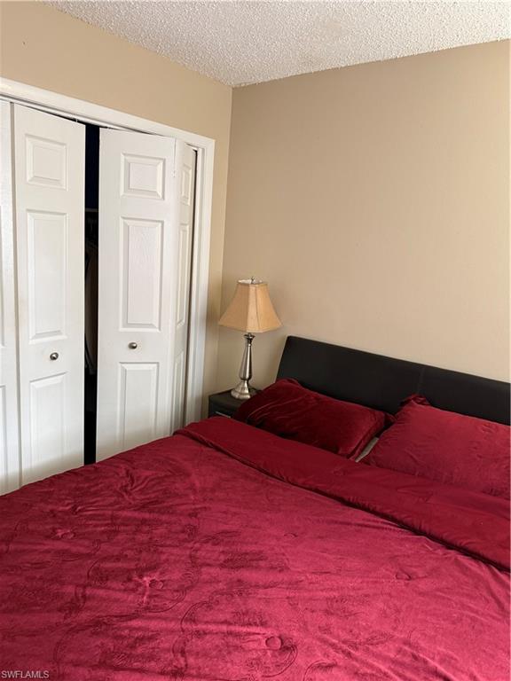 3325 Airport Road North, Unit R6 Naples, FL 34105 - Photo 7 of 11 Bedroom featuring a closet and a textured ceiling
