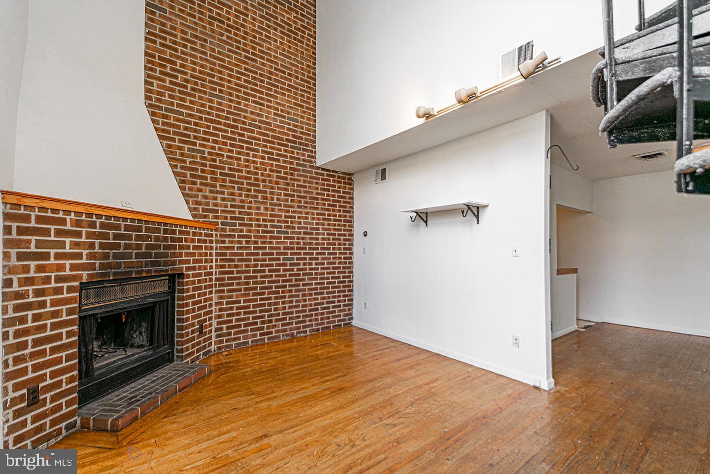 4118 Baltimore Avenue, Unit A Philadelphia, PA 19104 - Photo 4 of 25 a view of empty room with wooden floor and fireplace