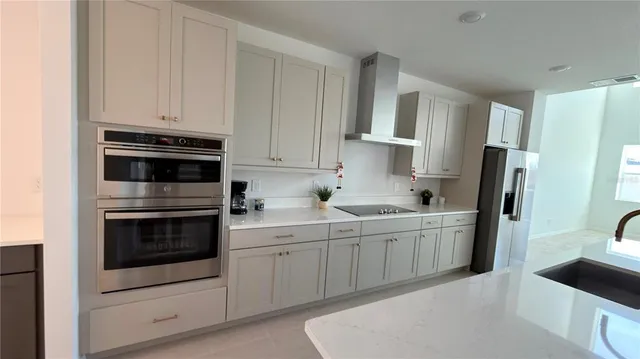 a kitchen with stainless steel appliances cabinets a sink and a refrigerator