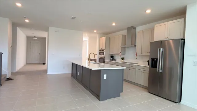 a kitchen with stainless steel appliances granite countertop a refrigerator and a sink