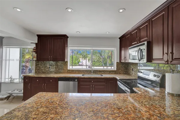 a kitchen with stainless steel appliances granite countertop a sink stove and cabinets