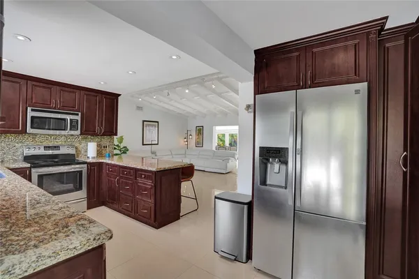 a kitchen with stainless steel appliances granite countertop a refrigerator stove and oven