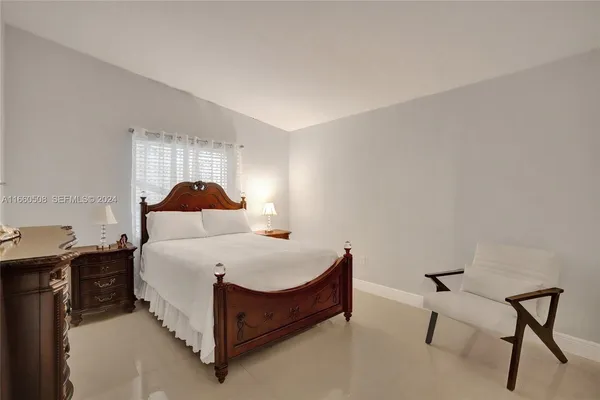 a bedroom with a bed and a lamp on desk