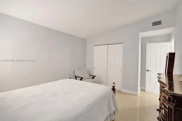 a bedroom with a bed and a flat tv screen on a dresser