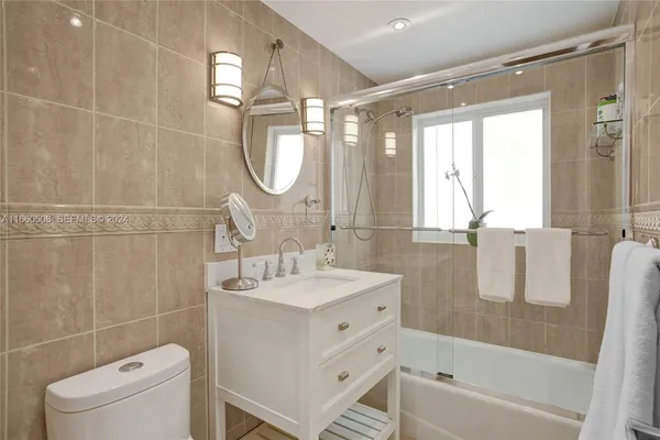 a bathroom with a granite countertop sink a toilet and a mirror