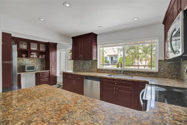 a kitchen with stainless steel appliances granite countertop a sink stove and refrigerator