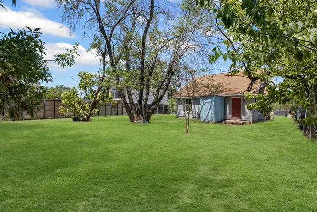 a view of a house with a yard and tree s