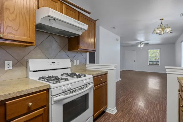 a kitchen with granite countertop a stove and a wooden floors