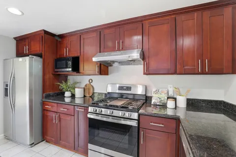 a kitchen with stainless steel appliances granite countertop a refrigerator stove and sink