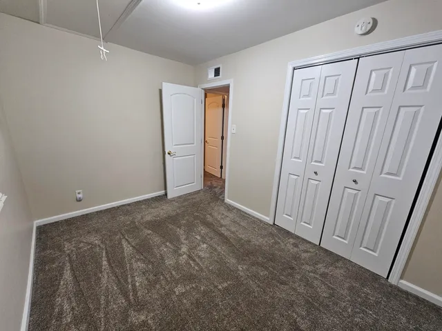 an empty room with a hardwood and windows