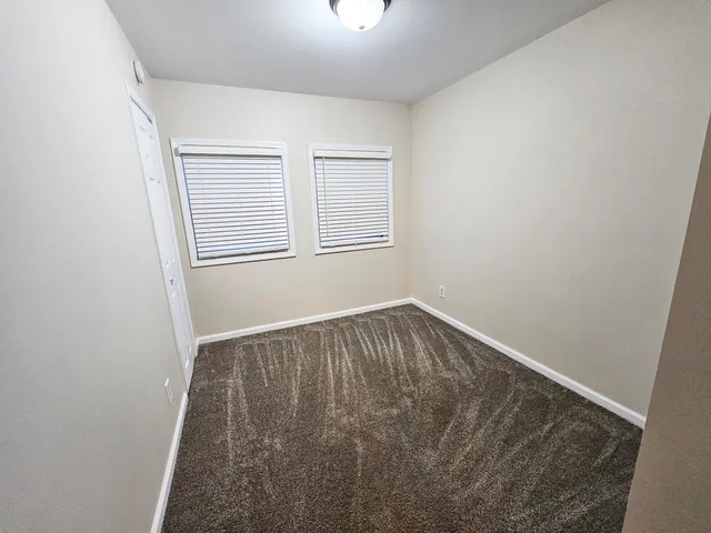 an empty room with wooden floor and mirror
