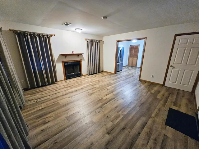 a view of a livingroom with wooden floor and staircase