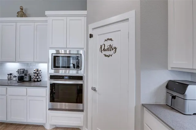 a kitchen with stainless steel appliances white cabinets and a refrigerator