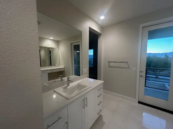 a spacious bathroom with a shower a sink and a mirror