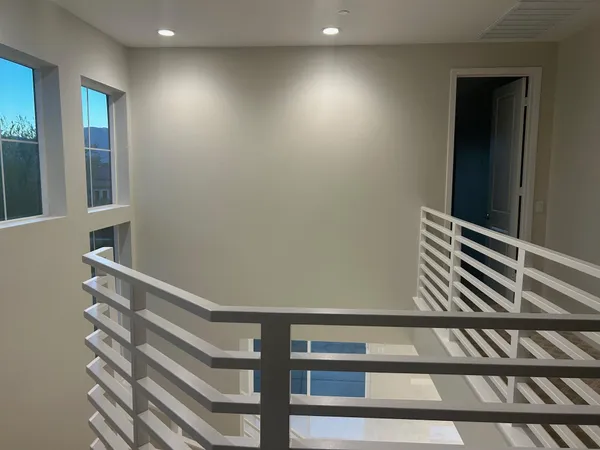 a view of a hallway with stairs and a window
