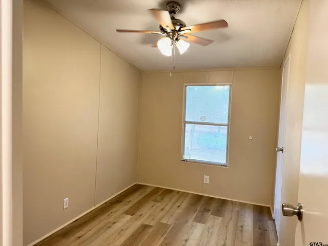 an empty room with a window and a fan