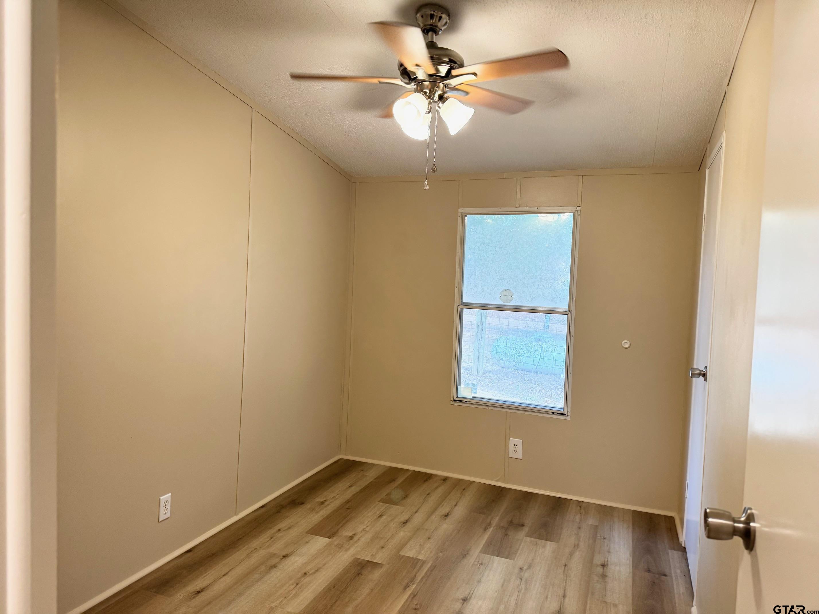 427 Old Latexo Road Grapeland, TX 75844 - Photo 15 of 18 an empty room with a window and a fan