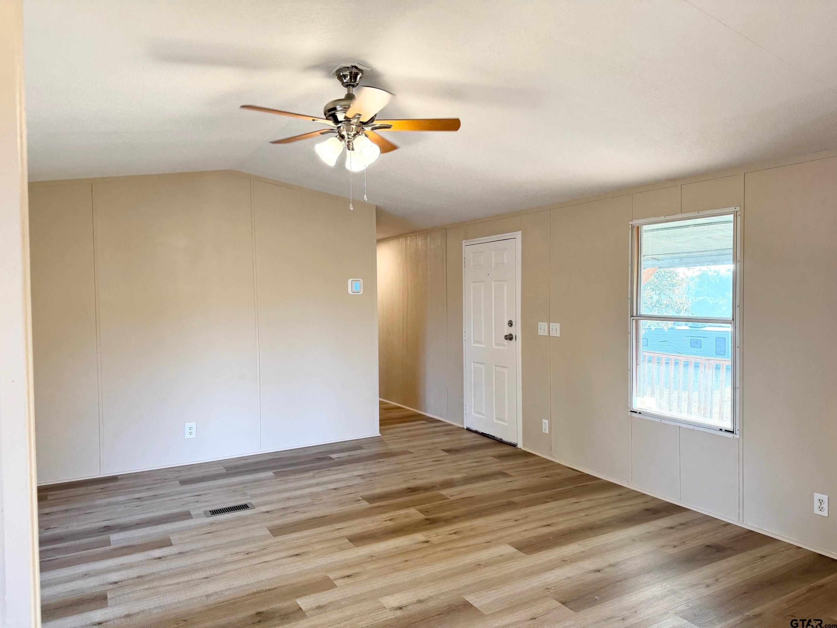 427 Old Latexo Road Grapeland, TX 75844 - Photo 5 of 18 a view of an empty room with wooden floor and a window
