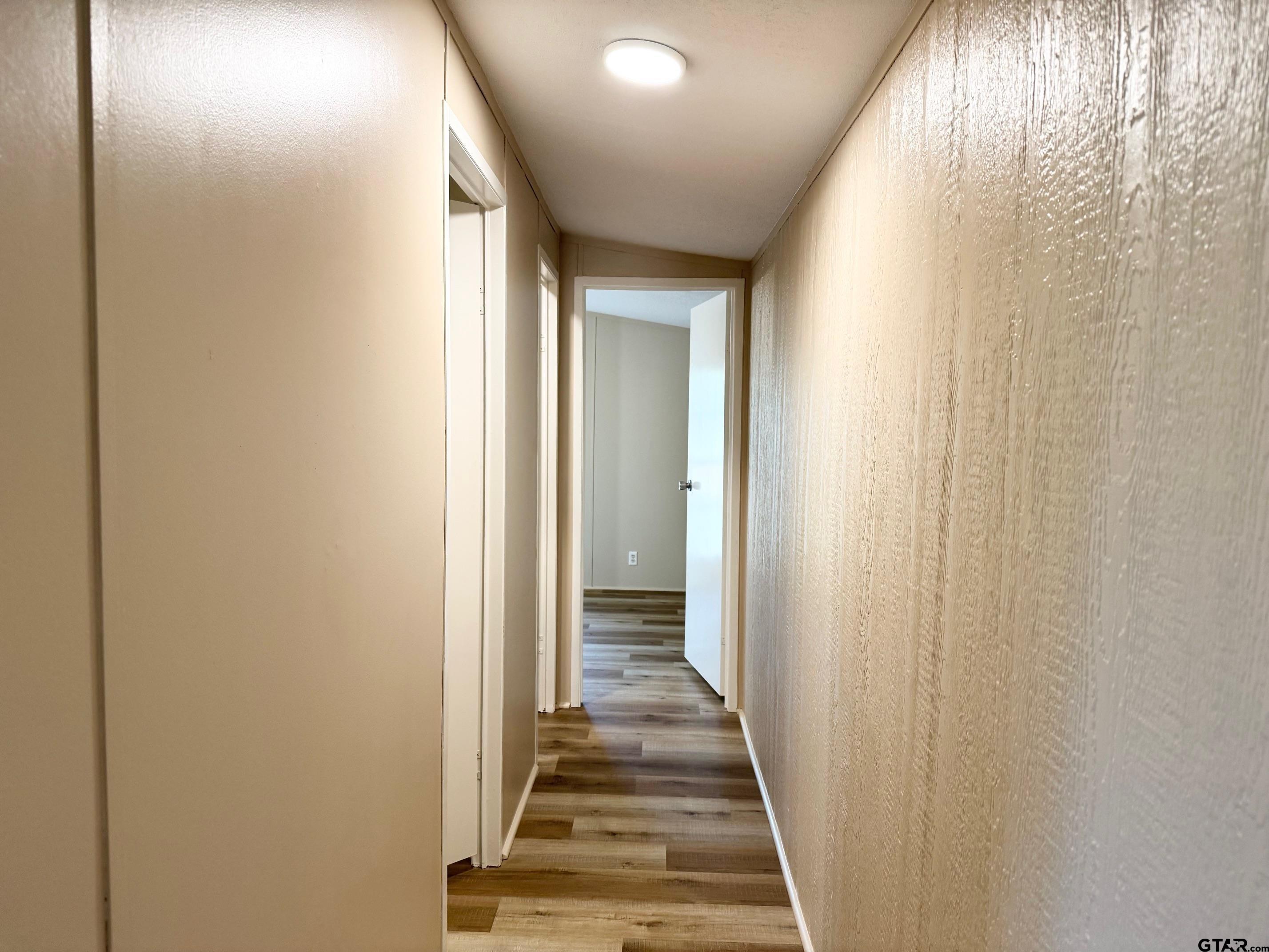 427 Old Latexo Road Grapeland, TX 75844 - Photo 9 of 18 a view of a hallway with wooden floor and a bathroom