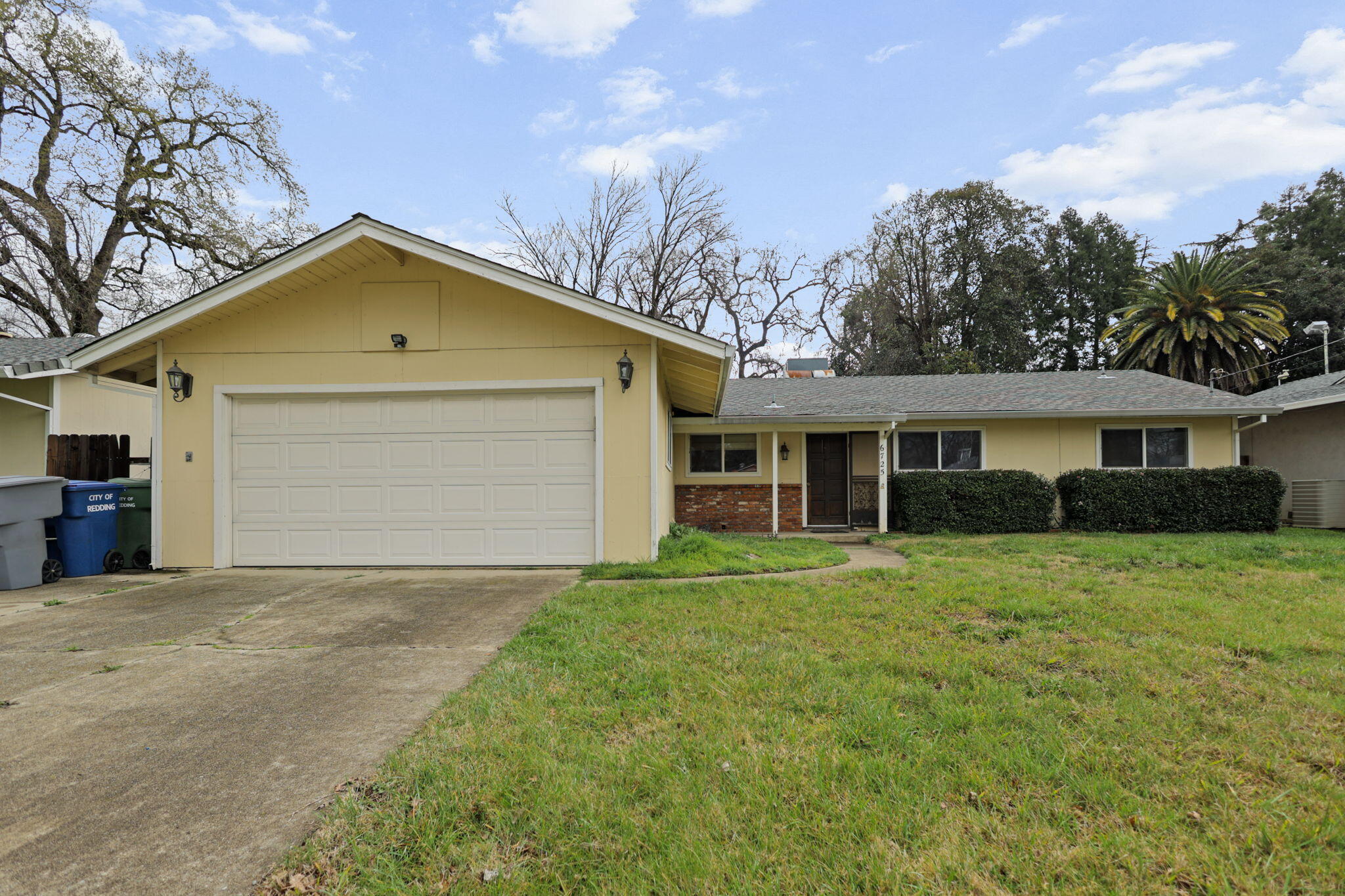 a view of a yard in front of a house with large trees