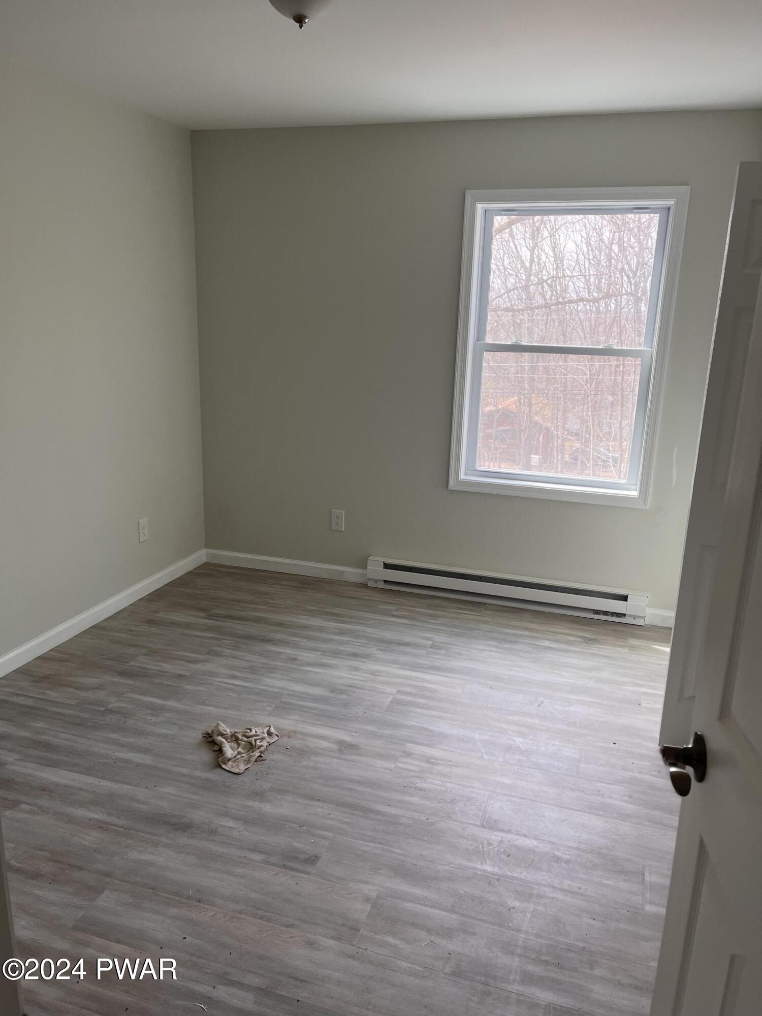 128 Stonehenge Road Milford, PA 18337 - Photo 10 of 14 an empty room with a wooden floor and a window