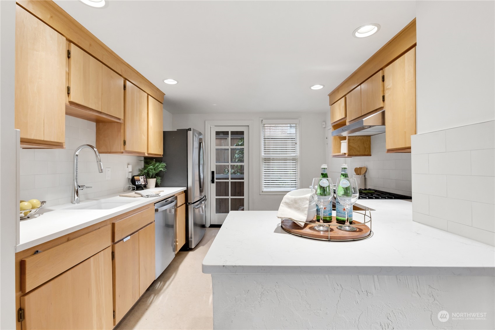 2114 North 65th Street Seattle, WA 98103 - Photo 19 of 40 a kitchen with kitchen island a sink a stove cabinets dining table and chairs