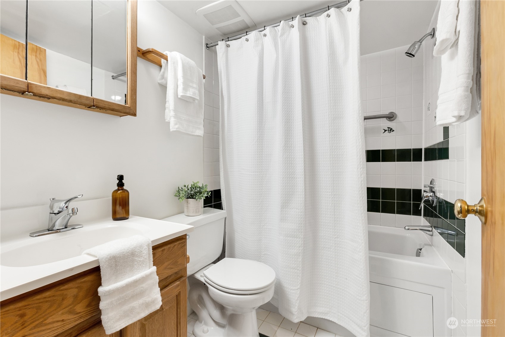 2114 North 65th Street Seattle, WA 98103 - Photo 32 of 40 a bathroom with a sink a toilet and shower curtain