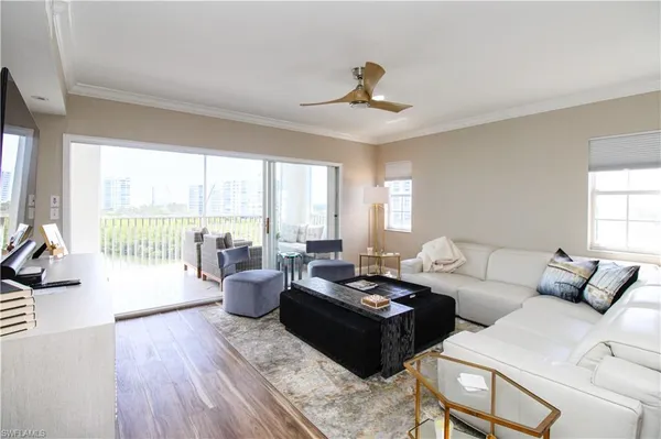 a living room with furniture and floor to ceiling windows