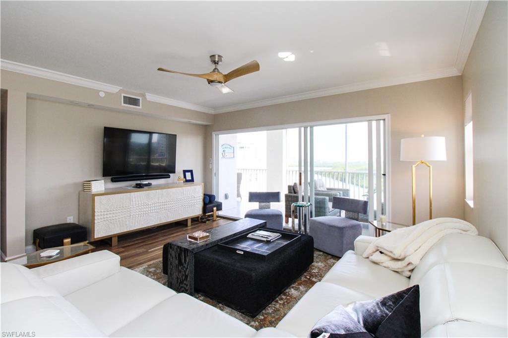 35 Bluebill Avenue, Unit B702 Naples, FL 34108 - Photo 16 of 50 a living room with furniture and a flat screen tv