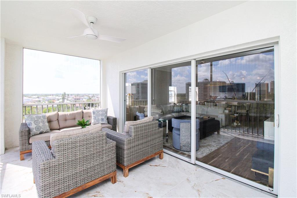 35 Bluebill Avenue, Unit B702 Naples, FL 34108 - Photo 17 of 50 a living room with furniture and a floor to ceiling window