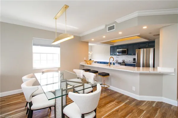 a kitchen with a dining table chairs and white cabinets