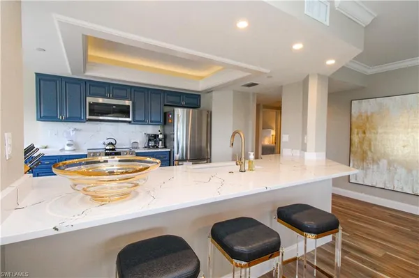 a kitchen with stainless steel appliances granite countertop a sink and a refrigerator