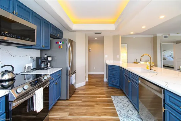 a large kitchen with stainless steel appliances granite countertop a stove a sink dishwasher and a microwave oven with cabinets