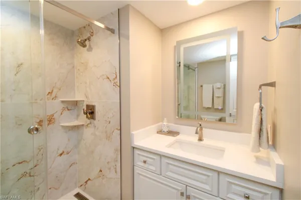 a bathroom with a shower sink vanity and mirror