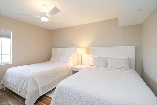 a bedroom with two beds and a ceiling fan