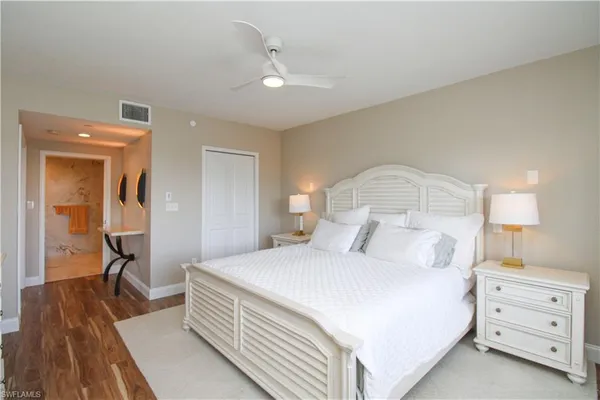 a bedroom with a bed and a lamp on dresser