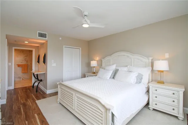 a bedroom with a bed and a lamp on dresser