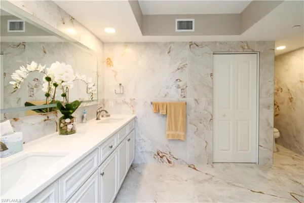 a bathroom with a double vanity sink mirror and shower
