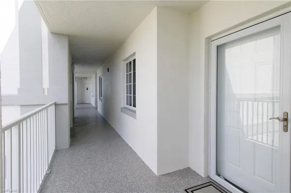 a view of a hallway with a room that has a window