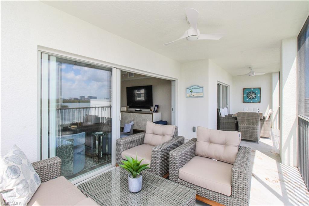 35 Bluebill Avenue, Unit B702 Naples, FL 34108 - Photo 10 of 50 a living room with furniture and a floor to ceiling window