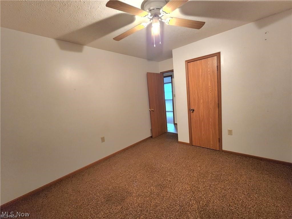 10345 Marne Road Frazeysburg, OH 43822 - Photo 34 of 50 Unfurnished bedroom with a textured ceiling, ceiling fan, and carpet