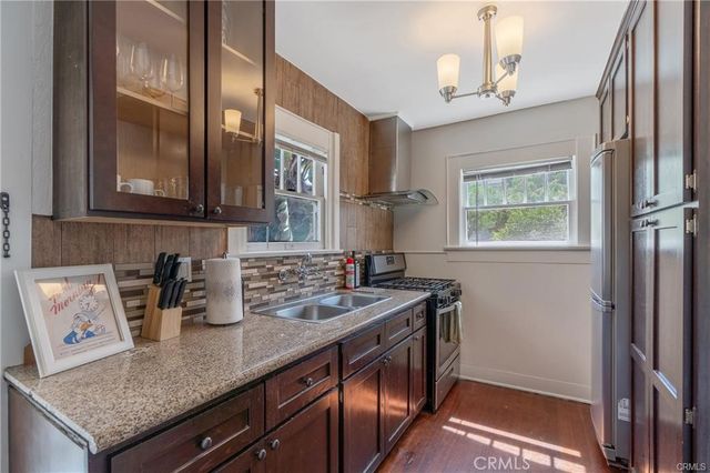 a kitchen with stainless steel appliances granite countertop a sink a stove and a refrigerator
