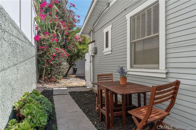 a backyard of a house with a fountain table and chairs