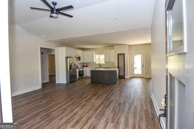 a kitchen with stainless steel appliances granite countertop a refrigerator and a stove top oven